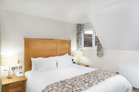 Elegant bedroom with luxurious bedding and charming decor accents.