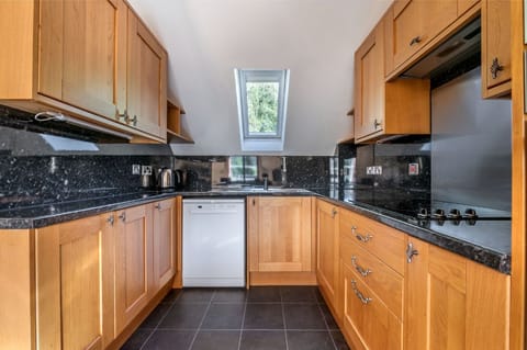 Kitchen with countertops and wooden cabinetry, ready for culinary activities.