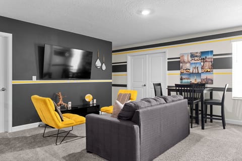Settle into your stylish living space where vibrant yellow accents pop against sleek gray tones, creating the perfect spot for relaxing evenings.