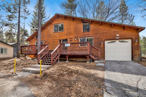 Welcoming cabin entry surrounded by towering pine trees, offering fresh mountain air and a peaceful forest setting—the perfect first impression for your Big Bear Lake getaway.