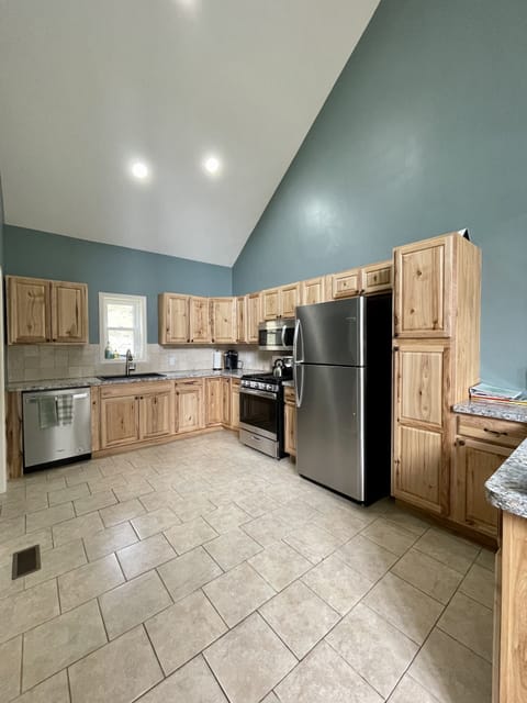 Large kitchen is fully stocked. Peninsula opens to dining room.