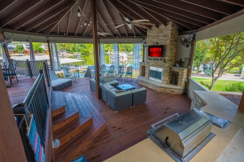 Comfy couches, tv, grill, fireplace, fans- an amazing outdoor space next to lake