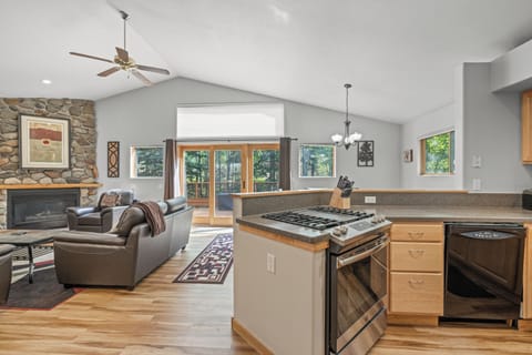 Bright, airy great room with vaulted ceilings, a cozy stone fireplace, and seamless flow from the kitchen’s gas range to the spacious living and dining areas. Large windows and sliding doors open to a private deck surrounded by Aspens, perfect for entertai