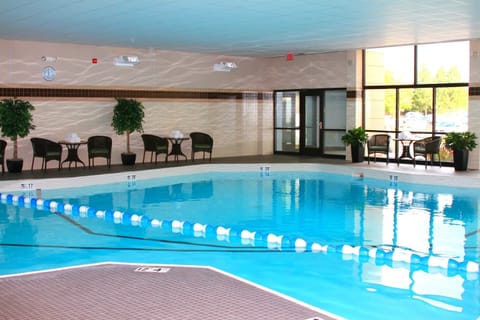Indoor pool with clear water and poolside seating.