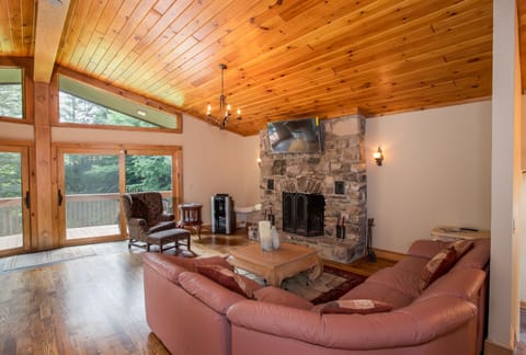 Great Room with Vaulted Ceilings, Wood Floors, Leather Sectional, and Glass Doors to Front Porch