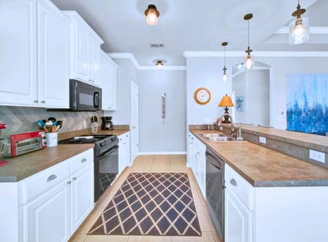 Gourmet Kitchen: Fully equipped with stainless steel appliances and a coastal-inspired backsplash.