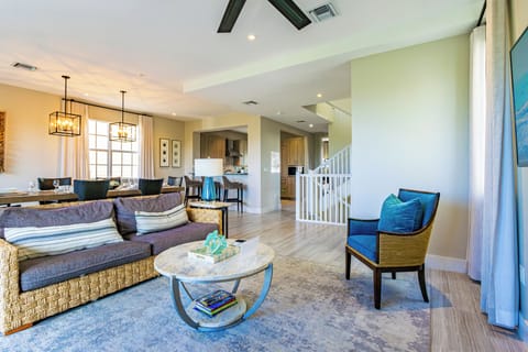 Comfortable lounge with modern furniture and easy access to the kitchen and stairs.