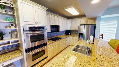 Kitchen featuring granite countertops, modern appliances, and bar seating.
