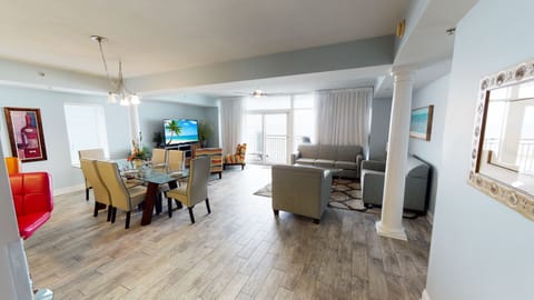 Relax in a bright, open living area with a dining space, comfortable seating, and large windows leading to ocean views.