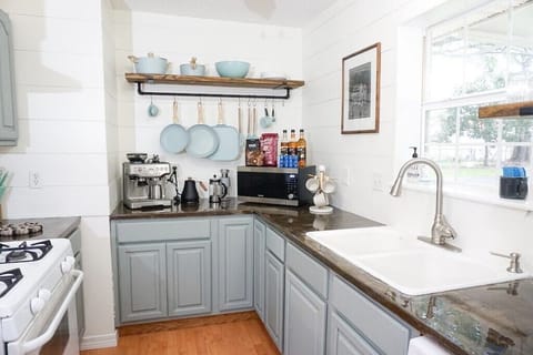 - Fully equipped kitchen featuring artisan cookware, a full coffee bar, and modern appliances - Open shelving and neutral tones create a warm, inviting culinary space - Thoughtfully stocked for both gourmet cooking and effortless morning routines