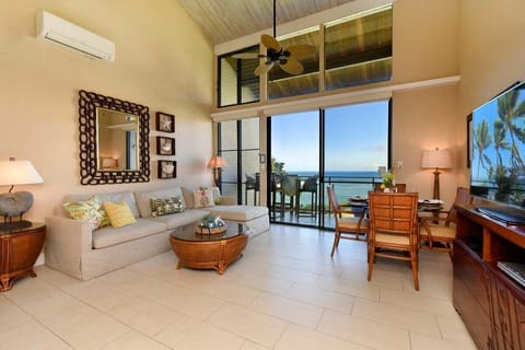 Bright, open-concept living with vaulted ceilings, AC, and floor-to-ceiling views of the water.