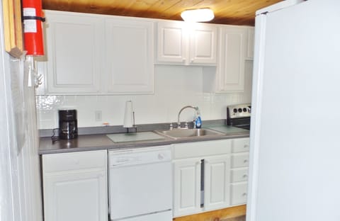 VIEW OF KITCHEN REEFRIGERATOR IN FOREGROUND.