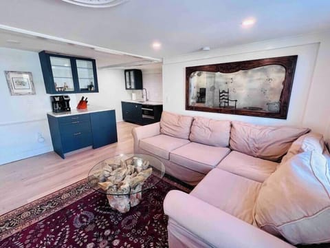 Spacious and open living area with large sectional sofa, 65" Samsung The Frame TV, and views out to Joppa Flats