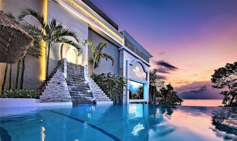 Water falls from 2 stainless steel sculptures, a pyramid and into infinity pool