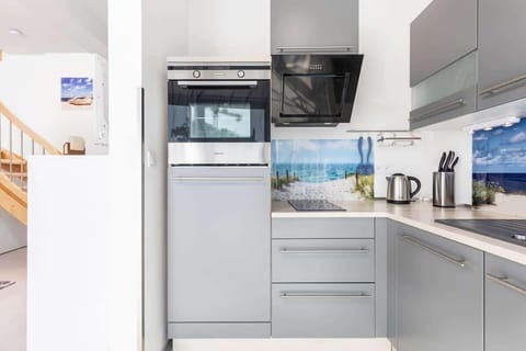 Another angle of the same kitchen or a similar one, showcasing a coffee maker and kettle with a simple backdrop.