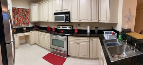 Kitchen with granite countertops and stainless steel appliances, tile flooring
