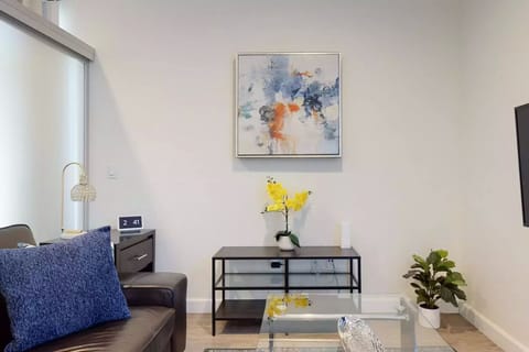 Colorful pillows, modern paintings, and plants create a relaxing atmosphere.