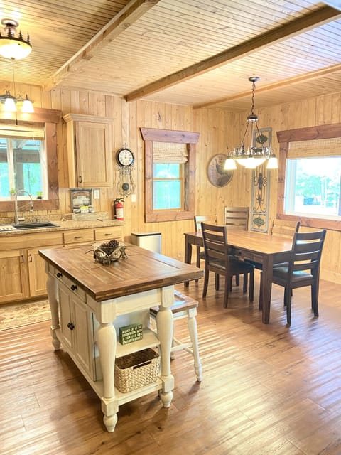 Large kitchen with new appliances, island + kitchen table with six chairs.
