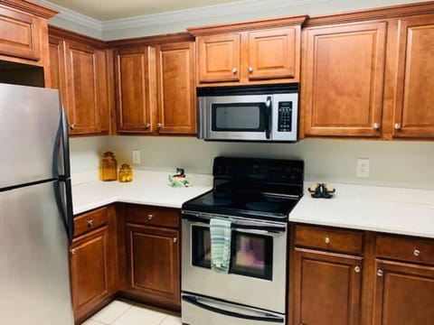 Kitchen with corian countertops, stainless steel appliances and a breakfast bar