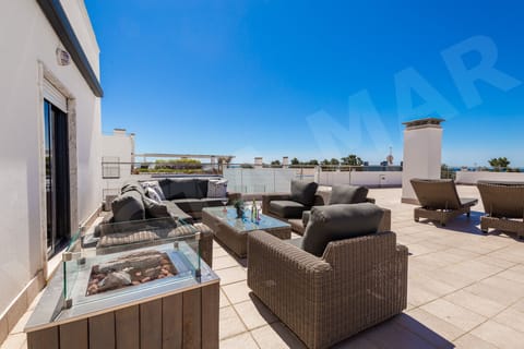 Spacious roof terrace with comfortable rattan seating, glass-top table and panoramic views at Apartment Vista Mar, a professionally cleaned 3-bedroom holiday apartment with barbecue close to Lagos town centre in the Algarve, Portugal