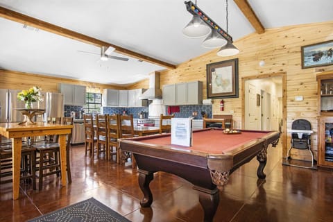 Enjoy meals, games, and good times in this bright kitchen and dining area featuring a pool table and farmhouse charm.