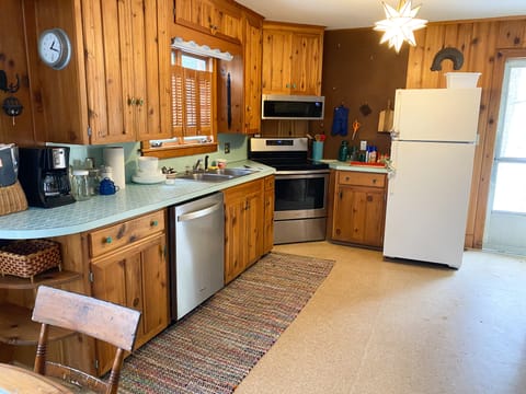 Open kitchen stocked with dishes and pots and pans and newer appliances