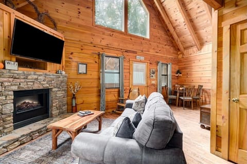 Living room with flat screen TV, electric fireplace, and queen sleeper sofa