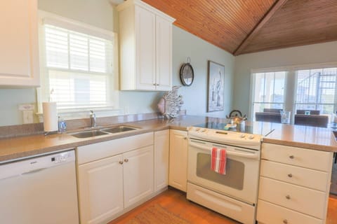 The Going Coastal kitchen has white cabinetry, a range, dishwasher and garbage disposal.