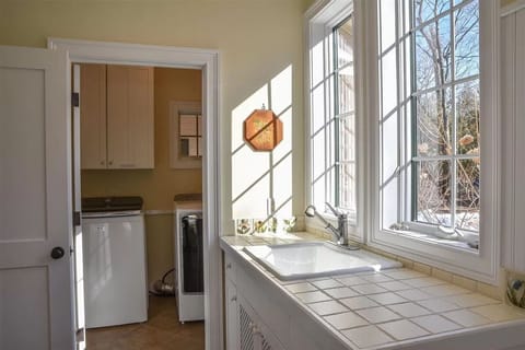 Commercial grade washer and dryer and deep wash sink in mudroom.