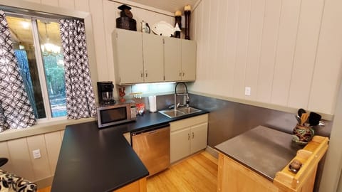 Kitchen view with dishwasher, microwave, coffee pot and bar area.