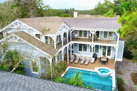 A coastal vacation home featuring a private swimming pool and hot tub surrounded by tropical landscape!.