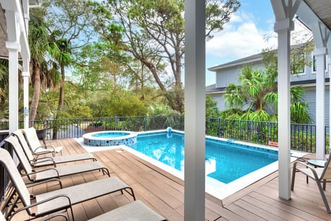 Unwind on your private deck where loungers await poolside, while the hot tub beckons for evening soaks under tropical palms.