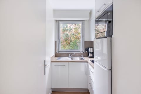 Bright and compact kitchen equipped with hobs, a microwave, and a coffee maker, making meal prep a breeze.