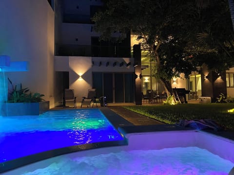 Amazing pool with waterfall and a hot tub and landscaping lights.  