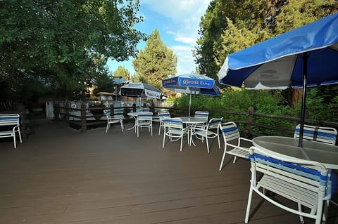 Gather outdoors for drinks and conversation under shaded umbrellas.