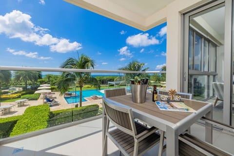 Sip your morning coffee on your private balcony overlooking tropical gardens, sparkling pools, and the vibrant landscape—your peaceful escape awaits just beyond the glass doors.
