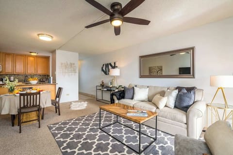 Experience open-plan living with a cozy sofa, dining area, and a fully equipped kitchen.