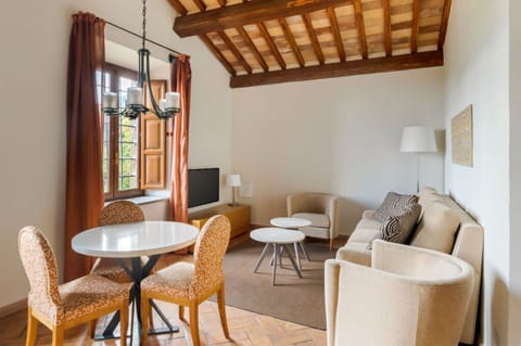 Gather beneath the timber ceiling of a sunlit living room that blends rustic Italian charm with modern ease.