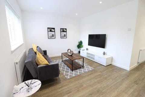 Spacious living room featuring a comfortable sofa and a 50`` Smart TV with Netflix subscription included.