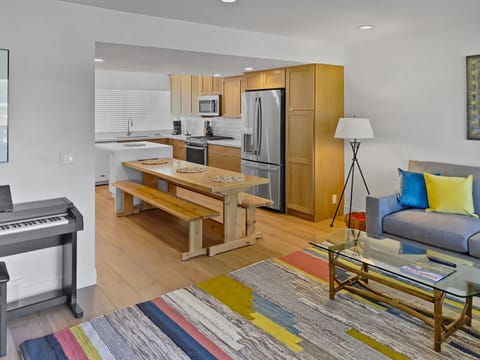 Prepare meals in our fully equipped kitchen, featuring a large island with bar seating, modern stainless steel appliances, and a stylish two-tone design. All the essentials for a great stay.