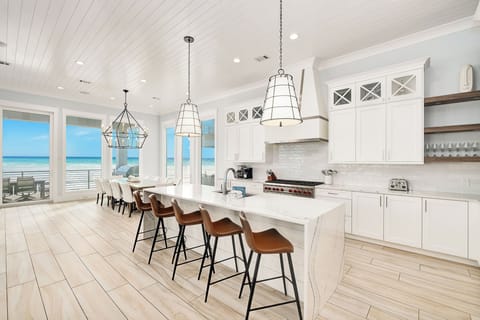 Your gourmet kitchen features a stunning ocean view, spacious island seating, and premium appliances for memorable coastal dining experiences.