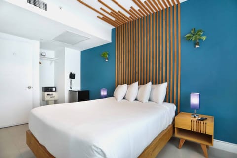 Sink into crisp linens beneath the striking designer headboard.