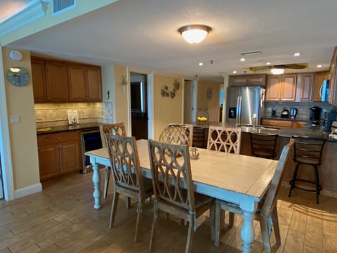 Dining table seating for 6 and 4 additional stools at the kitchen counter.