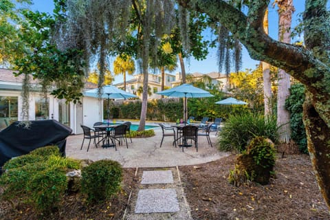 Your private backyard oasis awaits with a sparkling pool, shaded dining spots, and lush tropical landscaping for ultimate relaxation.