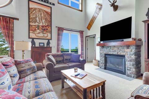 - Rustic lodge-style living room with stone fireplace and cozy mountain décor   - Spacious layout with large windows and scenic forest views   - Perfect ski getaway retreat near Stratton Mountain Resort