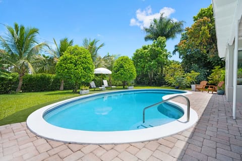 Private and secluded backyard with amazing pool surrounded by lush greenery.