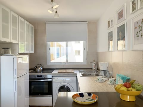 Kitchen with pleasant natural lighting, stove, refrigerator and all the necessities