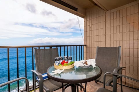 Private oceanfront, top floor lanai with island views and table set for al fresco dining