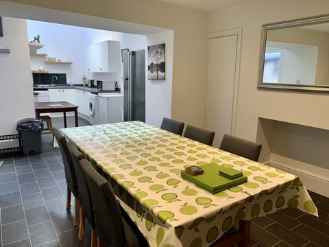Large dining table with open plan kitchen