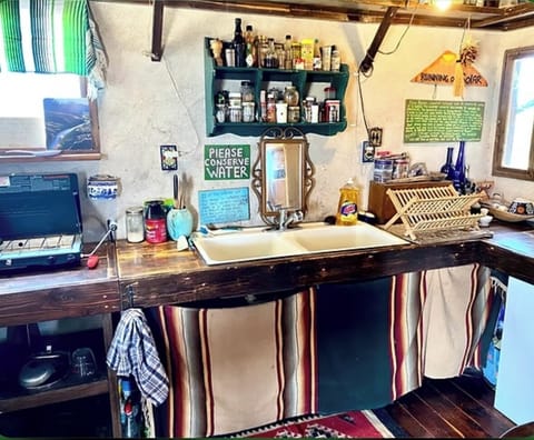 Our humble kitchen. Running water from water catchment. Stovetop. Fridge. 